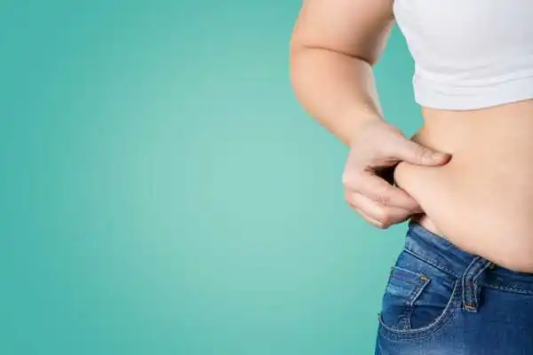 Image of woman pinching her love handles to show weight gain Hythe